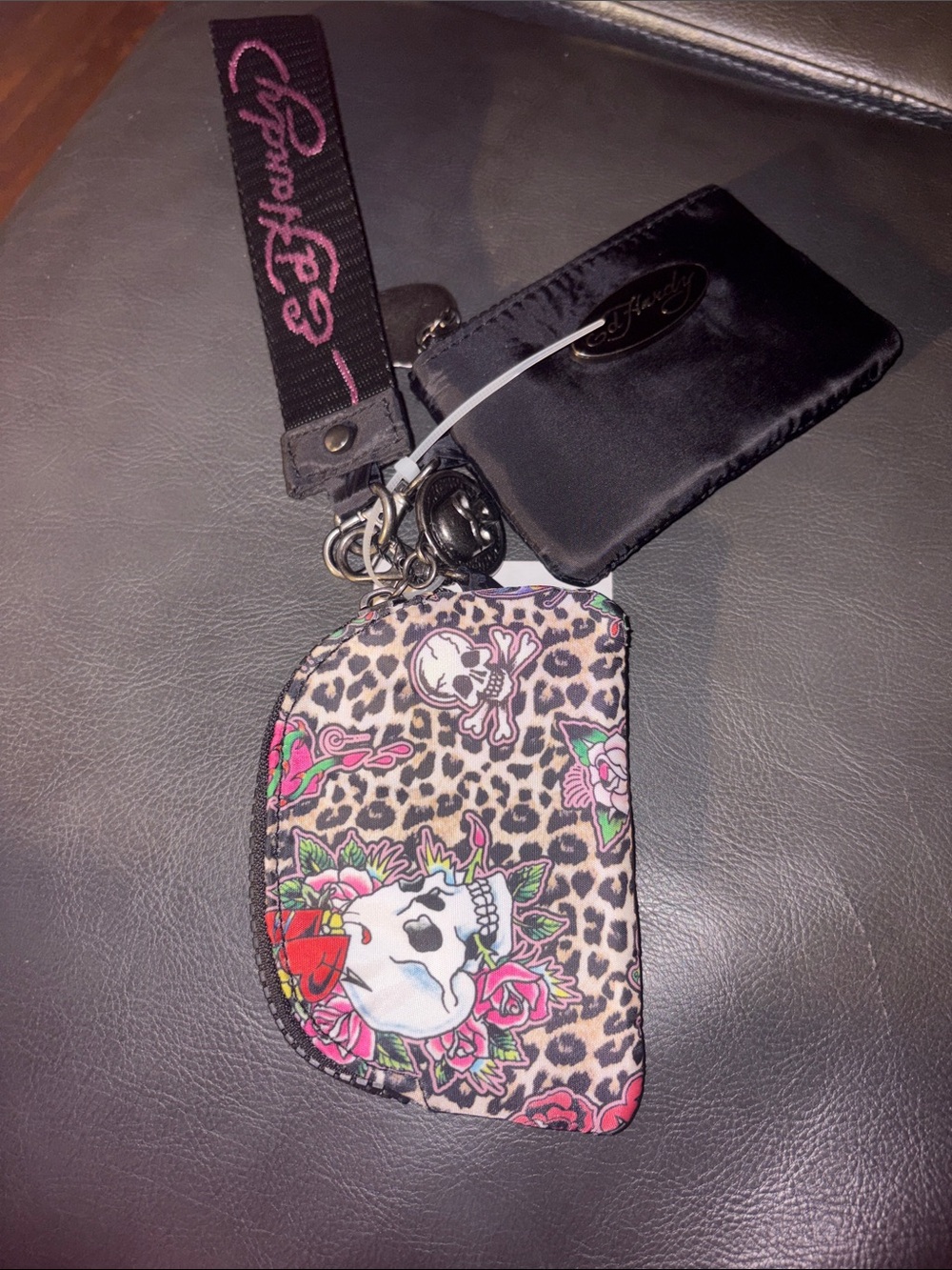 Ed Hardy card pouch with leopard print and skull-and-rose motifs.